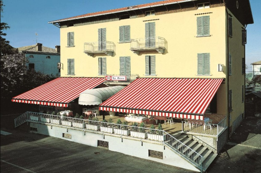 The Roma retractable awning is shown protecting a hotel restaurant dining area